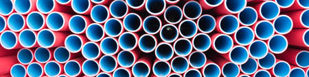 Lots of plastic pipes. The pipes are red on the outside and blue on the inside. Warehouse production. Circle, look inside.の写真素材