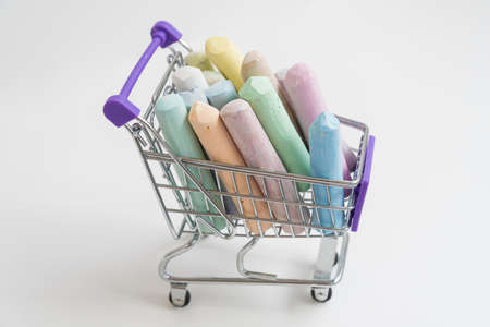 There are colored crayons in the shopping basket. The concept of buying. A variety of colors.の写真素材