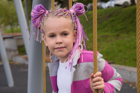 Portrait of a girl on a street Playground. A beautiful girl looks at the camera.