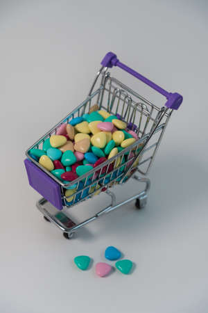 In the shopping basket are colorful hearts, candy. Candy in the form of colorful hearts.