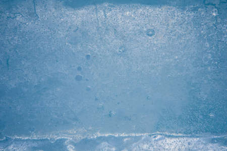 Close-up ice structure. Background in dark blue colors. Winter season, frost and cold.