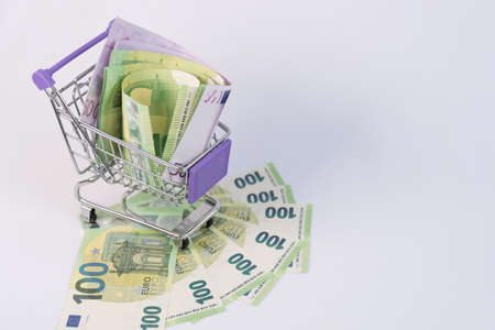 The shopping basket contains EU banknotes. The concept of selling, buying currency. Consumer basket....