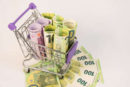 The shopping basket contains EU banknotes. The concept of selling, buying currency. Consumer basket....