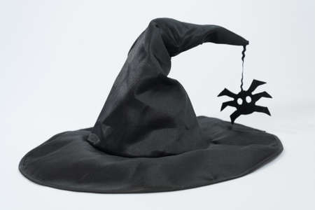 Black witch hat on a white background. Concept of magic and sorcery, stylish hat. Spiderの写真素材