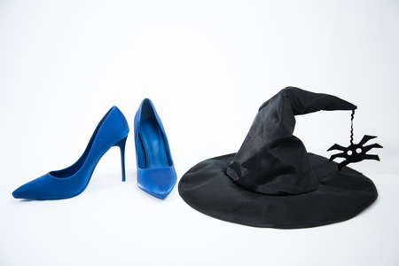 Witch hat and blue high-heeled shoes. The concept of the presence of a witch. Attributes of evil spiritsの写真素材