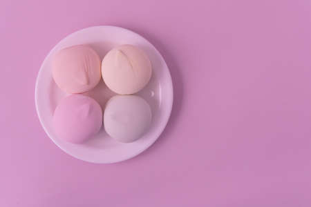 Marshmallow of delicate shades lies on a white teatka. Pink background, top view. There is room for textの写真素材