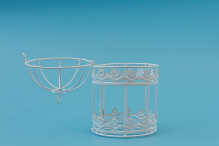 An empty open bird cage. A white cage on a blue background. Conceptの写真素材