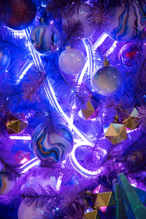 Christmas tree in trendy color 2022. Neon Christmas tree decorated with balls. Stylish and unusual...