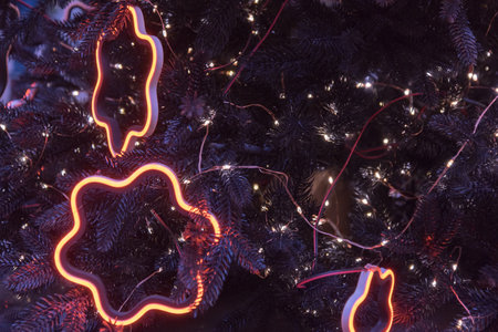 The Christmas tree is unusually decorated. The Christmas tree is decorated with neon toys. Fashion trend. Unusual and stylish Christmas tree.の写真素材