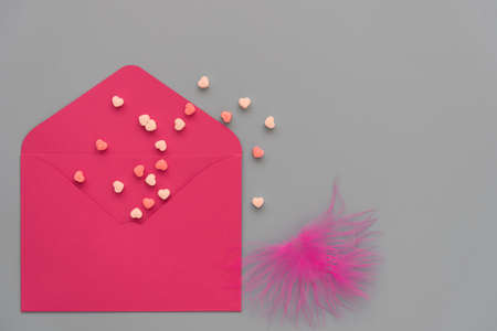 Stylish card for greetings on Valentines Day. On a gray background, a bright red envelope and tender...