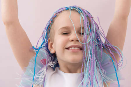 A beautiful teenage girl lifted up her multi-colored braids. Portrait. Natural emotions. Smile and...