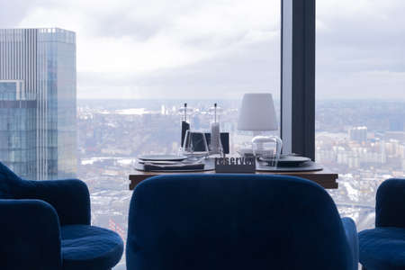 Stunning view of the city from the restaurant window. In the foreground is a table with cutlery and...