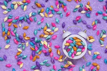 Alarm clock on the background of colorful shells. The concept of time for vacation and trip to the seaの写真素材