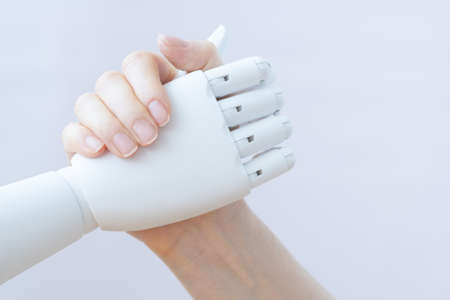 Human hand and robotic hand. Handshake and greeting. Prosthesis handshakeの写真素材