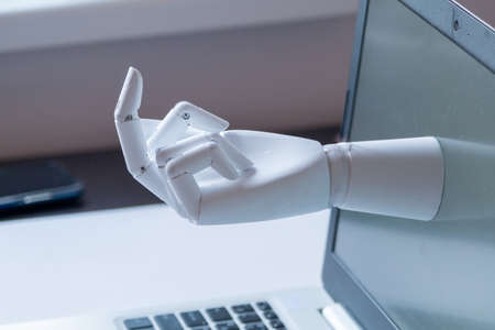 a robot hand with an indecent gesture is visible from the computer monitor. the concept of aggression in social networks and on the Internet. Conflictの写真素材