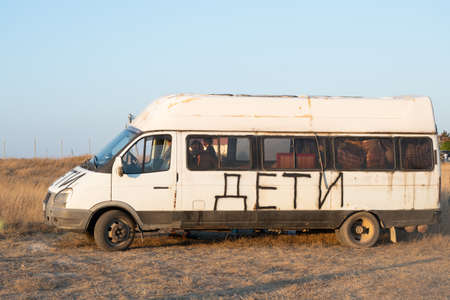 Minibus with the inscription CHILDREN on board. The inscription - CHILDREN on the car to avoid shelling the car. Saving the lives of passengers. Departure of refugees with children. Shot cars during the war in Ukraine.の写真素材