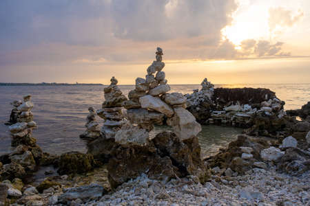 The stones are laid out in a column. Weathered marine limestone. Bizarre shape of stones on the seashoreの写真素材