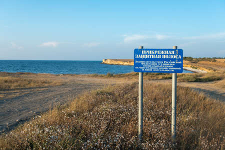 Republic of Crimea, August 4, 2022 Coastline of the sea. The inscription in Russian: Coastal protective strip. The legislation of the Russian Federation establishes a special regime for the implementation of economic and other activities.の写真素材