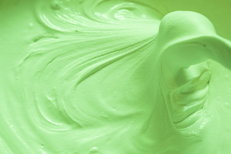 Mixing building mix. Putty for walls. Beautiful slow motion, the texture of the putty is clearly visible. Delicate green colorの写真素材