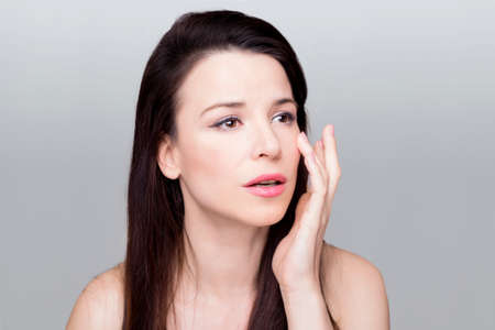 Beautiful woman touching her faceの写真素材