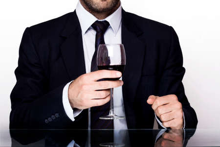 Business man holding a glass of wineの写真素材