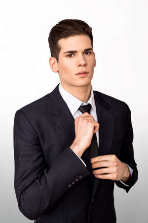 Young businessman adjusting tieの写真素材