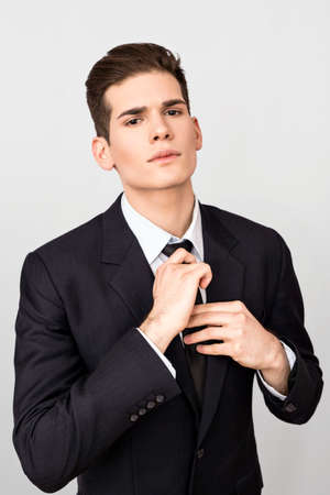 Young man adjusting tieの写真素材