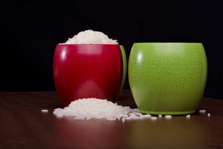 Rice spilled in colorful bowlsの写真素材