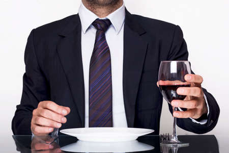 Businessman dining with a glass of red wineの写真素材