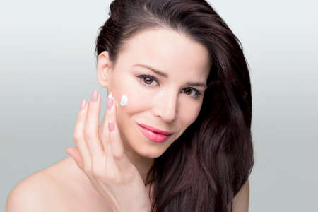 Beauty shoot of a woman apllying face creamの写真素材