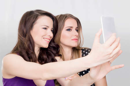 Girls taking a selfie with a cell phoneの写真素材