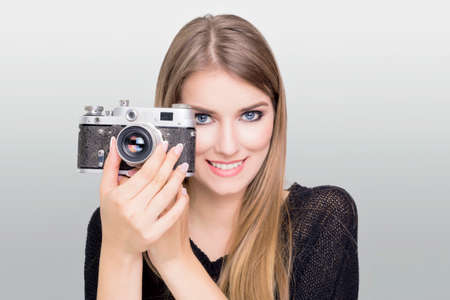 Blonde taking a photo with vintage camera