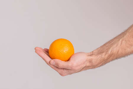 An orange in hand isolatedの写真素材