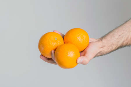Oranges in hand isolatedの写真素材