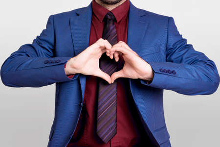 Businessman in red shirt showing a heart shapeの写真素材
