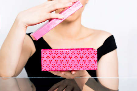 Woman opening a pink gift boxの写真素材