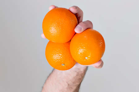 Three oranges in a handの写真素材