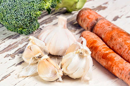 Carrots garlic and broccoli on a vintage tableの写真素材