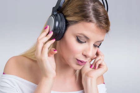 Blonde woman enjoying music on headphonesの写真素材