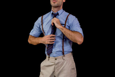 Man holding his tie in suspendersの写真素材
