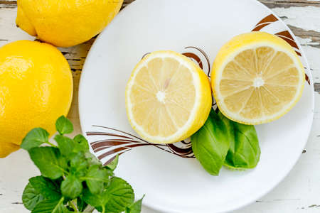 Lemon half in a plate and basil leavesの写真素材