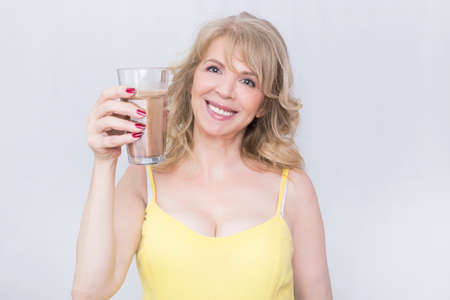 Blonde woman holding a glass of coffeeの写真素材
