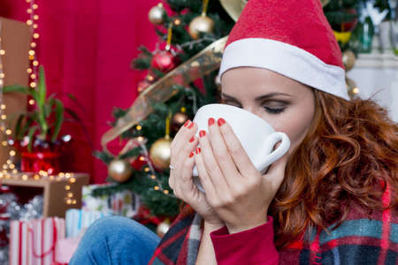 Redhead woman drinking tea on Christmasの写真素材