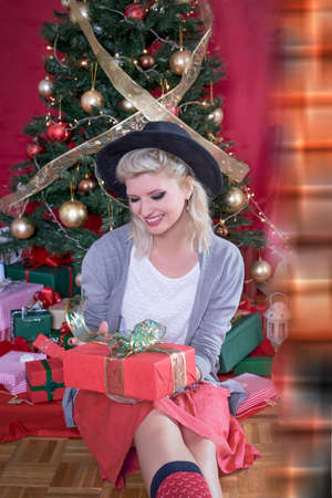 Vintage shot of a girl holding a gift on Christmasの写真素材
