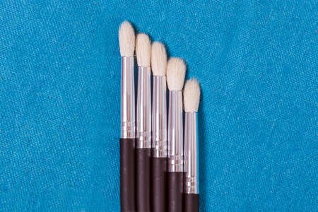 Paint brushes set on blue fabricの写真素材