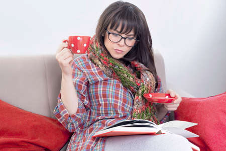 Hipster woman reading in sofaの写真素材
