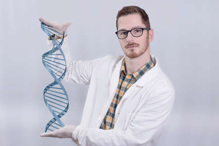 Redhead scientist showing a DNA chain helixの写真素材