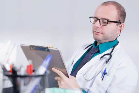 Doctor writing down in an officeの写真素材