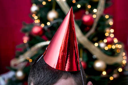 Christmas symbol with a red party cap on a mans head