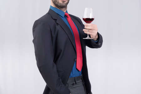 Man making a toast with a glass of red wineの写真素材